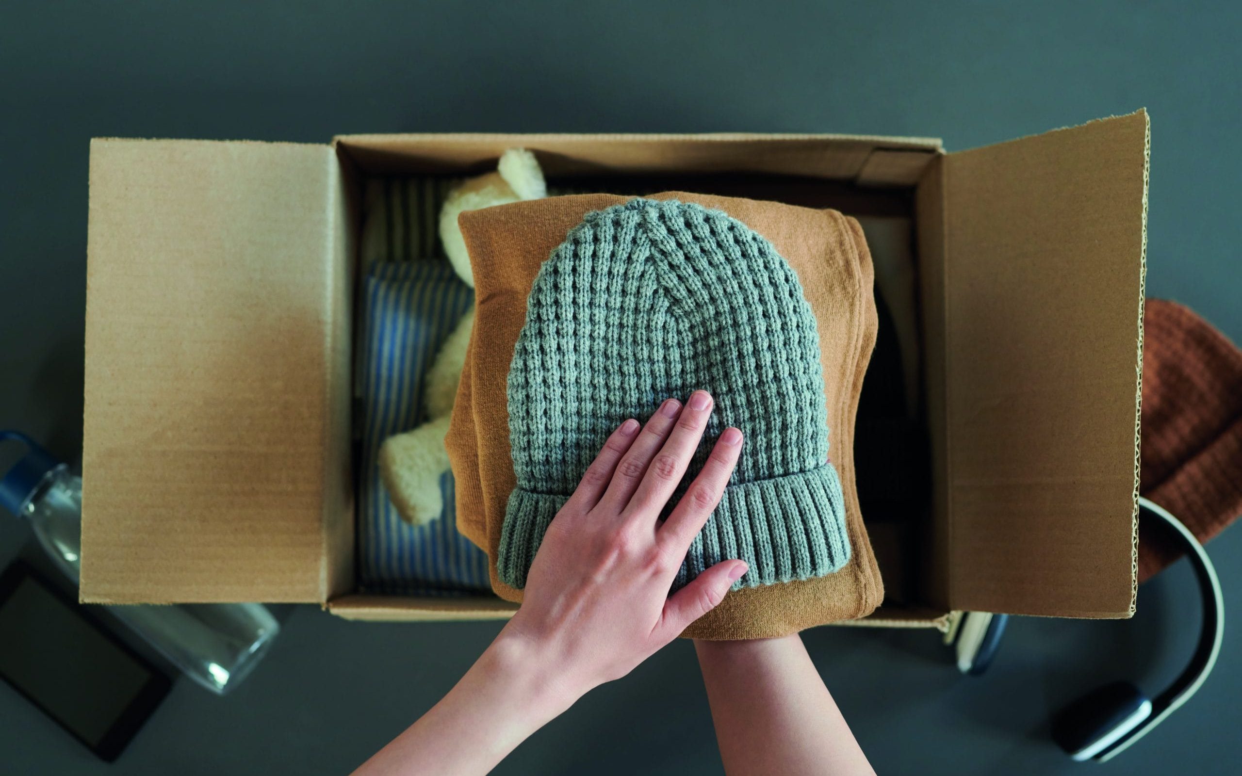 A Man Packs Pieces of Clothing in a Box Free Stock Photo by Everypixel